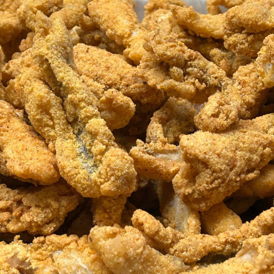 A basket of golden cornmeal-battered catfish nuggets, fried crisp.